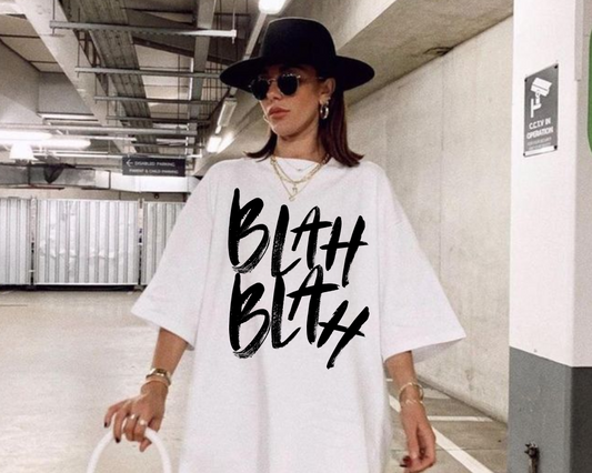 Woman wearing a white oversized t-shirt with black text in an indoor setting